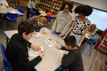 Eight graders helped sixth graders complete a coloring activity inspired by